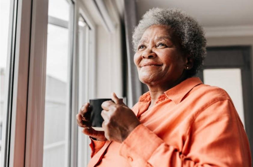 A senior woman relaxing with a cup of coffee in an independent living space, emphasizing the peaceful and comfortable lifestyle for older adults
