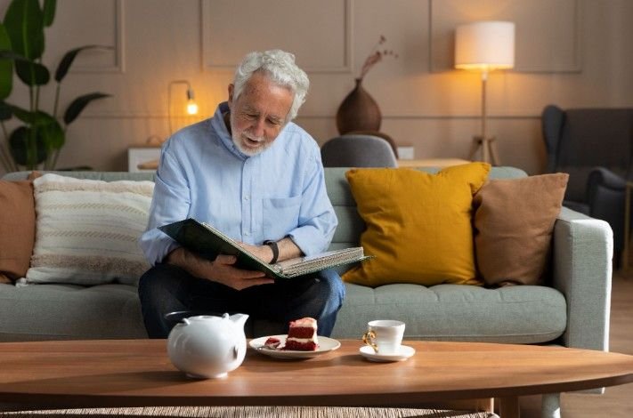 Caregivers assisting elderly man with photos. Tips on how to start a senior care business and home health services.